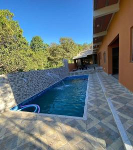 una piscina al costado de un edificio en Sítio Pequeno Sonho, en Jaboticatubas