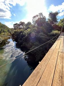Un puente de cuerda sobre un río con árboles y agua. en Sítio Pequeno Sonho, en Jaboticatubas 26 fotos más