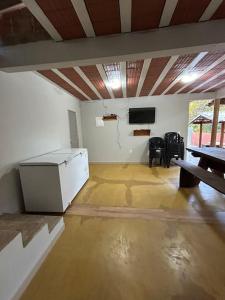 Una habitación vacía con una mesa y un televisor en la pared. en Sítio Pequeno Sonho, en Jaboticatubas