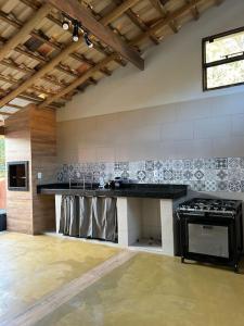 Una cocina con encimera negra en una habitación. en Sítio Pequeno Sonho, en Jaboticatubas
