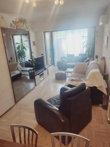 a living room with a couch and a mirror at bel Appartement les pieds dans l'eau in Villeneuve-Loubet