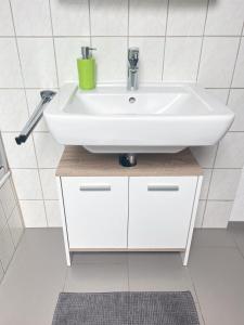 een badkamer met een witte wastafel bovenop kasten bij Ferienwohnung Malk in Traben-Trarbach