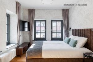 Un pat sau paturi într-o cameră la Browar Hevelius Apartments