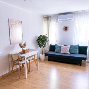 a living room with a blue couch and a table at Studio Aiora in Valencia