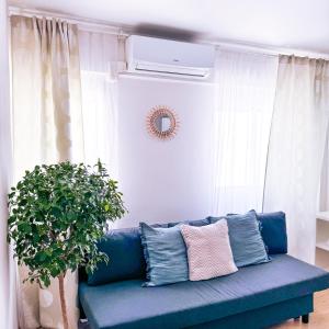 a blue couch in a living room with a plant at Studio Aiora in Valencia +24 photos