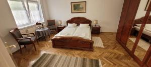 a bedroom with a large bed and a mirror at Kiskatona Vendégház in Balatonkenese