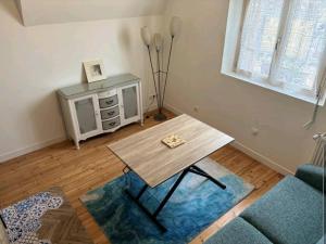 a living room with a table and a couch at Villa B in La neuville roy +3 photos