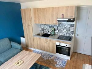 a small kitchen with a stove and a couch at Villa B in La neuville roy