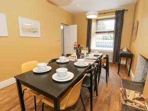 jadalnia z czarnym stołem i krzesłami w obiekcie Dale Cottage w mieście Llanrwst