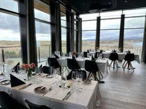 una sala da pranzo con tavoli, sedie e finestre di Hotel Varmaland a Varmaland