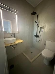a bathroom with a toilet and a sink and a shower at Eden - A Night near Athens Int Arpt in Spata