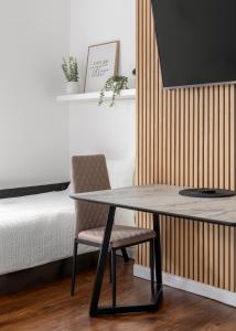 倫敦的住宿－Cosy Apartment in Queens Park，卧室配有桌子和床边的椅子