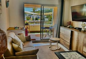 a living room with a couch and a sliding glass door at Appartement en face mer in Six-Fours-les-Plages