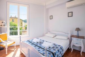 a bedroom with a bed and a chair and a window at Charming air conditioned 1 bedroom close to beach in Villefranche-sur-Mer