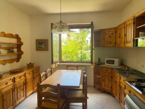 a kitchen with a wooden table and a window at Casa Isa in Narni Scalo