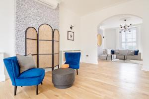 uma sala de estar com duas cadeiras azuis e uma mesa em Sonder Camden Road em Londres