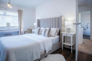 une chambre blanche avec un grand lit avec des oreillers blancs dans l'établissement Sunderland Avenue - 2 Bedroom - Pembroke Dock, à Pembroke Dock