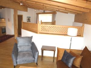 a living room with two chairs and a balcony at Kaiserapart Steinadler - ELLMAU Zentrum in Ellmau