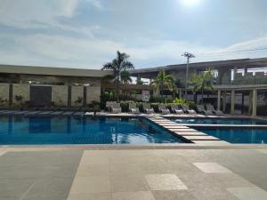 a swimming pool with lounge chairs and a building at Studio Type BNB Accommodation in Bacolod +8 photos