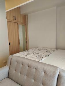 a bedroom with a large bed with a wooden cabinet at Studio Type BNB Accommodation in Bacolod
