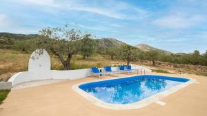 a swimming pool with blue chairs and a swimming poolvisor at Residenza Belvedere in Orosei