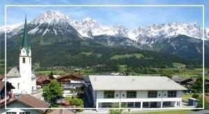 a town with a church and mountains in the background at Kaiserapart Steinadler - ELLMAU Zentrum in Ellmau