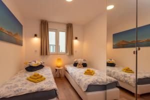 2 camas individuales en una habitación con espejo en Villa Serenum en Šibenik