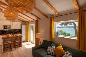 a living room with a green couch and a large window at Villa Serenum in Šibenik