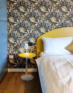a bedroom with a yellow table next to a bed at Appartamento Con Vista Mozzafiato in Lazise