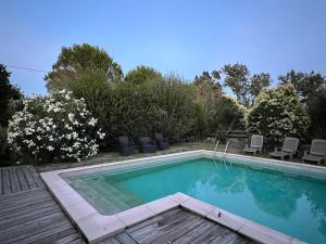 einen Pool im Garten mit Stühlen und Bäumen in der Unterkunft Mas de l'Estiou in Monteux