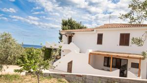 a white house with the ocean in the background at Residenza Belvedere in Orosei