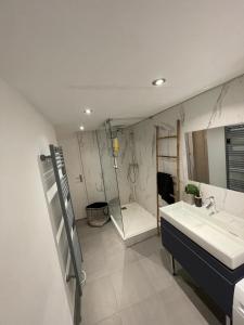 Appartement Design sur Vauban - Clim et Wifi في مارسيليا: حمام مع حوض ومرآة وحوض استحمام