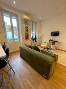 Appartement Design sur Vauban - Clim et Wifi في مارسيليا: غرفة معيشة مع أريكة خضراء كبيرة في غرفة