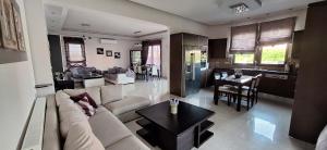 a living room and kitchen with a couch and a table at Rhodian Villa in Kremasti