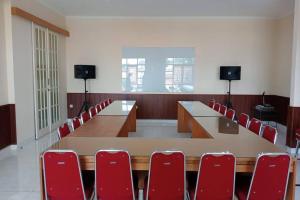 a conference room with a long table and red chairs at Puri Sawo Manila Residence in Jakarta