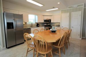 a kitchen with a wooden table and a stainless steel refrigerator at One More Time Again by Pristine Properties Vacation Rentals in Mexico Beach