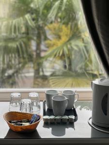 a tray with cups and glasses on a table with a window at parklane guest house in Cardiff