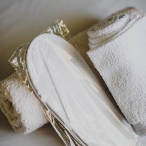 ein Stapel weißer Handtücher auf einem silbernen Tablett in der Unterkunft Relaxation apartment in Messini