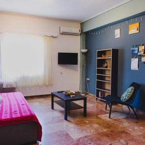 - un salon avec un lit, une table et une télévision dans l'établissement Relaxation apartment, à Messini