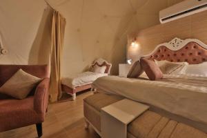 a bedroom with a large bed and a chair at Panorama Luxury Camp in Wadi Rum