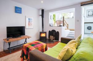 a living room with a couch and a fireplace at Soap Barn - 1 Bedroom Cottage - Manorbier in Manorbier