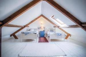 a attic room with two beds and a window at Haggard - 3 Bedroom Cottage - Manorbier in Manorbier