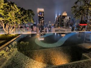 een zwembad met een skyline van de stad op de achtergrond bij Axon Apartment Bukit Bintang At KL in Kuala Lumpur