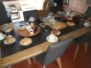 einen Tisch mit Frühstückszutaten darüber in der Unterkunft Le Clos Fleuri in Vineuil