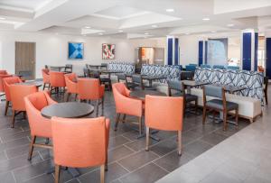 un comedor con mesas y sillas naranjas en Holiday Inn Express Kearney, an IHG Hotel, en Kearney