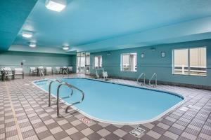 una piscina en una habitación grande con mesas y sillas en Holiday Inn Express Kearney, an IHG Hotel, en Kearney
