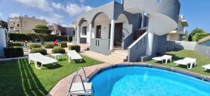 a villa with a swimming pool in front of a house at Rhodian Villa in Kremasti