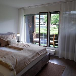 a bedroom with a bed and a view of a balcony at Aare Studio 2 in Interlaken