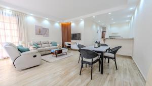 a living room with a table and chairs and a couch at Amazing Golf View Apartments in 6th Of October