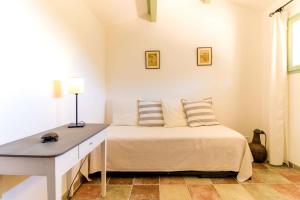 een slaapkamer met een bed en een bureau. bij SELECT'SO HOME - Mas au cœur du village de Bormes-les-mimosas - MAS DE LA VERNE in Bormes-les-Mimosas